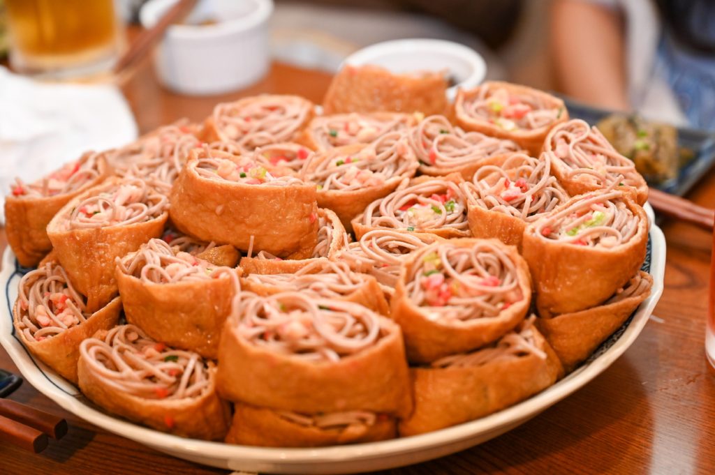 A plate of soba inari, fried tofu pouch filled with buckwheat noodles.