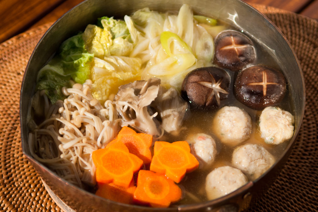 Chanko nabe with chicken meatballs, shiitake mushrooms, and vegetables.